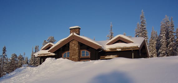 hus bakom snövall